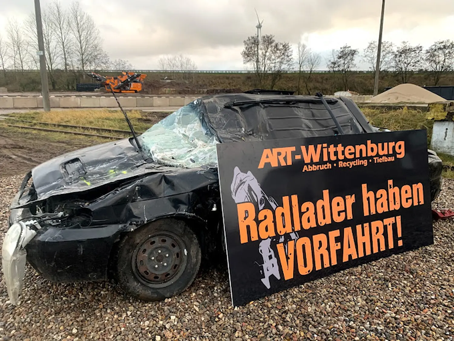 Beschädigtes Auto und Firmenbanner von ART Wittenburg 